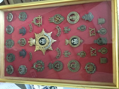 Lot 808 - Victorian Essex Regiment Officers' Helmet plate together with a collection of Essex Regiment and Essex Yeomanry badges, mounted in a glazed frame.