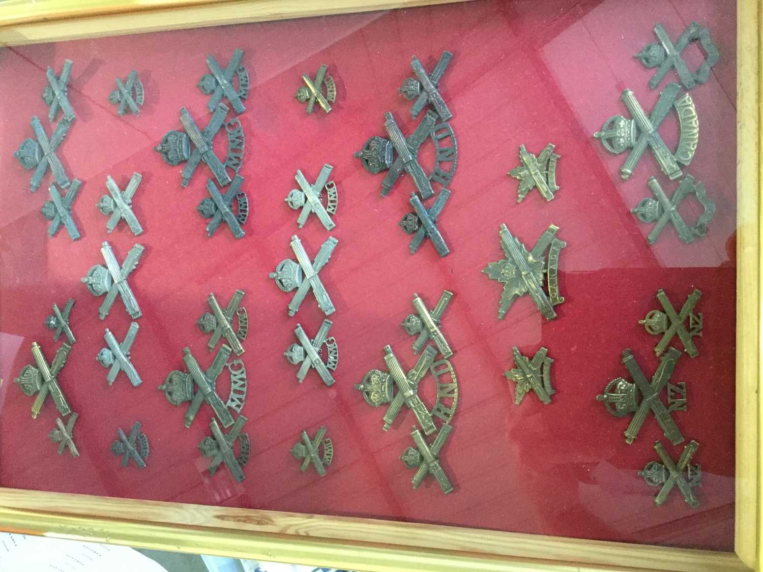 Lot 809 - Collection of British and Commonwealth Machine Gun Regimental badges mounted in glazed frame (37 badges)