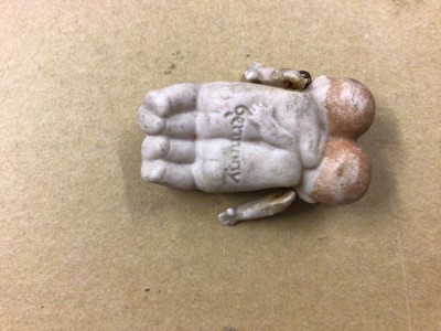 Lot 2429 - Dolls - German Bisque Conjoined miniature twins with pin jointed arms, in miniature green ceramic bed.