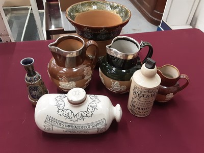Lot 1175 - Doulton Lambeth stoneware items, including two silver mounted jugs, a small vase, a jardiniere, a foot warmer, a small jug and a ginger beer bottle (7)