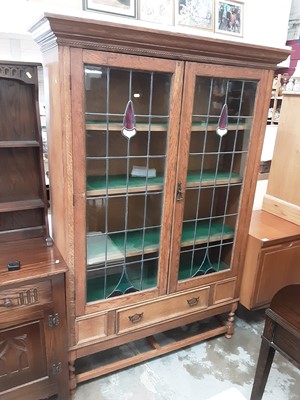 Lot 1025 - Early 20th century oak bookcase/display cabinet with shelved interior enclosed by two tinted and leaded glazed doors, single drawer below on spiral twist supports, 125cm wide, 41cm deep, 181.5cm hi...