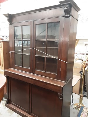 Lot 1027 - Late 19th century oak two height bookcase with shelved interior enclosed by two glazed doors, frieze drawer and two panelled doors below, small circular Heals label to back of bookcase top, 155cm w...