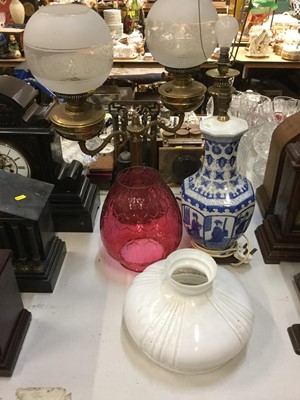 Lot 485 - Chinese blue and white porcelain table lamp, together with a brass oil lamp, brass table lamp and cranberry glass oil lamp shade