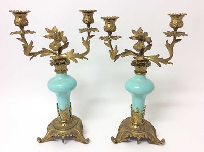 Lot 83 - Pair of rococo ormolu and porcelain twin branch candelabra, with bulbous duck egg inverted baluster porcelain stem and removable twin scrolling foliate branches with removable sconces, on scrolling...