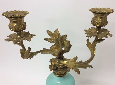 Lot 83 - Pair of rococo ormolu and porcelain twin branch candelabra, with bulbous duck egg inverted baluster porcelain stem and removable twin scrolling foliate branches with removable sconces, on scrolling...