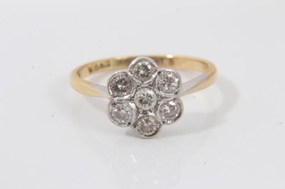 Lot 565 - Diamond cluster ring with a flower head cluster of seven brilliant cut diamonds in platinum millegrain setting on 18ct yellow gold shank