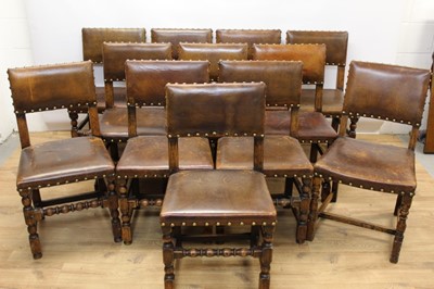 Lot 1429 - Set of twelve Cromwellian style oak and brown leather dining chairs with padded backs and seats and brass studded leather upholstery