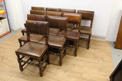 Lot 1429 - Set of twelve Cromwellian style oak and brown leather dining chairs with padded backs and seats and brass studded leather upholstery