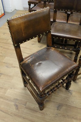 Lot 1429 - Set of twelve Cromwellian style oak and brown leather dining chairs with padded backs and seats and brass studded leather upholstery