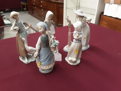 Lot 1166 - Four Lladro porcelain figures and a Nao figure (5)