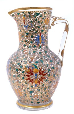 Lot 103 - Fine enamelled glass jug, mid to late 19th century, decorated with Persian-style scrolling foliate patterns in red, blue, green, yellow and white enamels, with gilding in relief, 25.5cm high