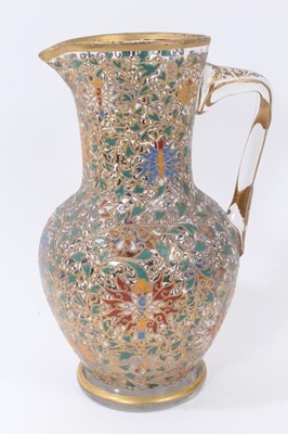 Lot 87 - Fine enamelled glass jug, mid to late 19th century, decorated with Persian-style scrolling foliate patterns in red, blue, green, yellow and white enamels, with gilding in relief, 25.5cm high