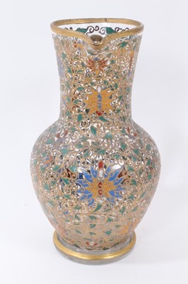 Lot 103 - Fine enamelled glass jug, mid to late 19th century, decorated with Persian-style scrolling foliate patterns in red, blue, green, yellow and white enamels, with gilding in relief, 25.5cm high