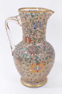 Lot 87 - Fine enamelled glass jug, mid to late 19th century, decorated with Persian-style scrolling foliate patterns in red, blue, green, yellow and white enamels, with gilding in relief, 25.5cm high