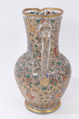 Lot 221 - Fine enamelled glass jug, mid to late 19th century, decorated with Persian-style scrolling foliate patterns in red, blue, green, yellow and white enamels, with gilding in relief, 25.5cm high
