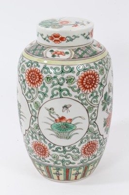 Lot 106 - Chinese famille verte ovoid porcelain vase and cover, 19th century, decorated with panels of flowers on a scrolling foliate-patterned ground, 21cm high