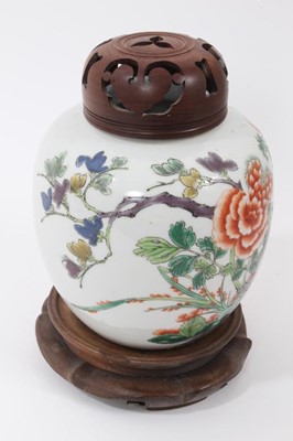 Lot 119 - Chinese famille verte porcelain jar, 18th/19th century, decorated with a tropical bird perched on rockwork, surrounded by flowers and foliage, together with carved wooden cover and stand, 13.5cm hi...