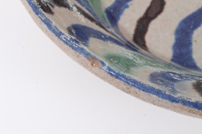 Lot 120 - Persian/Middle Eastern tin-glazed pottery bowl, painted with a bird and a foliate pattern in blue, green and black, 24.5cm diameter
