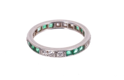 Lot 513 - Diamond and emerald full band eternity ring with a trio of brilliant cut diamonds alternating with three calibre cut emeralds. Ring size L.