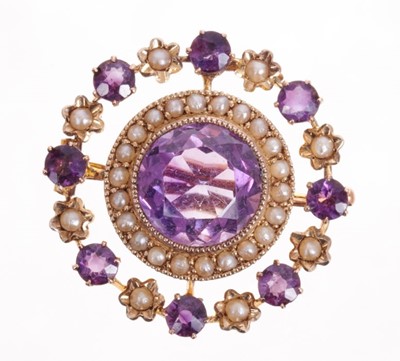 Lot 519 - Late Victorian gold amethyst and seed pearl pendant/brooch, the circular wreath design with a central round mixed cut amethyst surrounded by seed pearls with stylized floral border. 26mm diameter.