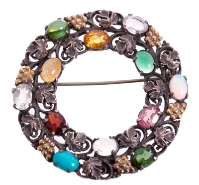 Lot 520 - Bernard Instone (1891-1987) a silver and multi-gem wreath brooch with oval cut and cabochon gem-stones within a fruiting vines. Signed. 48mm diameter.