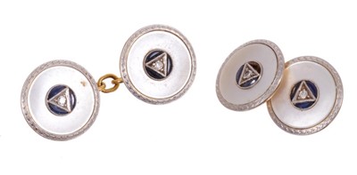 Lot 523 - Pair of Art Deco 18ct gold dress cufflinks, the circular mother of pearl disc centred with a diamond and synthetic blue sapphires in 18ct white and yellow gold mount. Diameter 14.5mm.