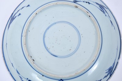 Lot 134 - Chinese blue and white porcleain dish, Kangxi period, decorated with a phoenix perched on rockwork, surrounded by flowers, double ring mark to base, 22cm diameter