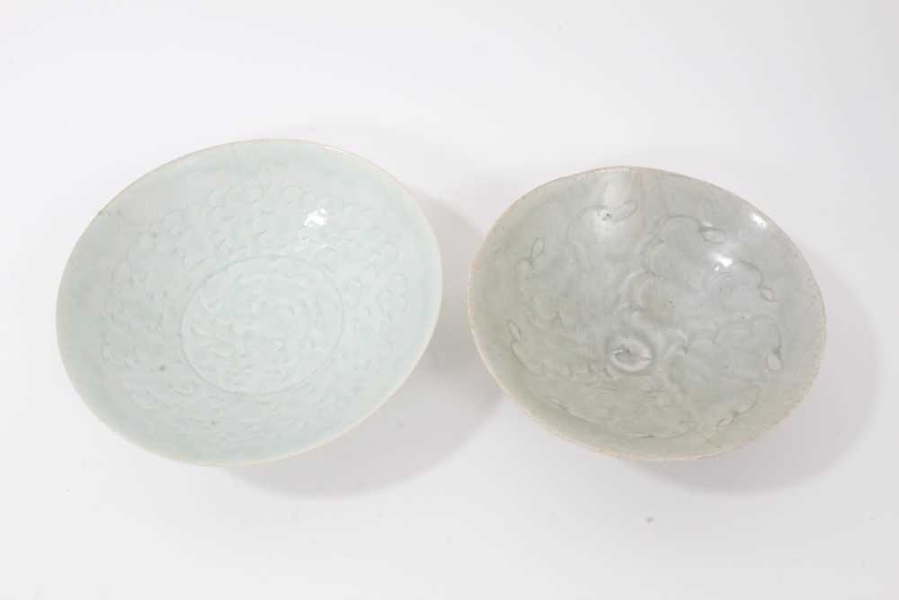 Lot 135 - Two early Chinese bowls, probably Song Dynasty, one with a Qingbai glaze and incised with a cloud pattern, 19cm diameter, the other with a greyish-green celadon glaze, incised with a similar patter...