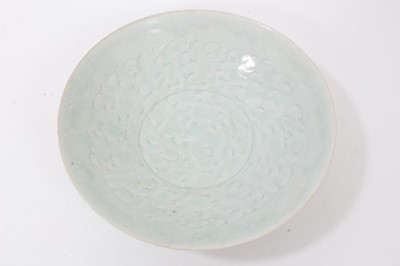 Lot 135 - Two early Chinese bowls, probably Song Dynasty, one with a Qingbai glaze and incised with a cloud pattern, 19cm diameter, the other with a greyish-green celadon glaze, incised with a similar patter...