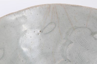 Lot 135 - Two early Chinese bowls, probably Song Dynasty, one with a Qingbai glaze and incised with a cloud pattern, 19cm diameter, the other with a greyish-green celadon glaze, incised with a similar patter...