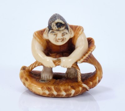 Lot 799 - A Japanese ivory netsuke, in the form of Edisu, the god of fishing, standing on a giant sea bream