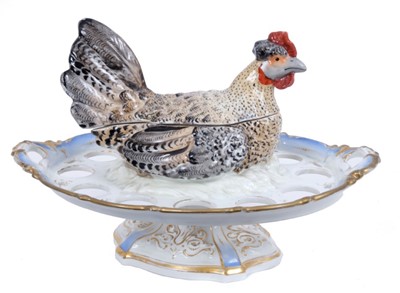 Lot 838 - Decorative Continental novelty china egg stand by Pirkenhammer, in the form of a hen, with removable cover and pierced tier for eggs, on spread base, printed marks, 38cm wide