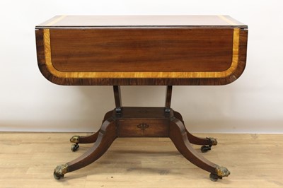 Lot 1322 - Regency mahogany, satinwood and rosewood crossbanded sofa table, the rounded rectangular drop leaf top over ebony inlaid end frieze drawer and opposing dummy drawer on lyre supports to platform and...