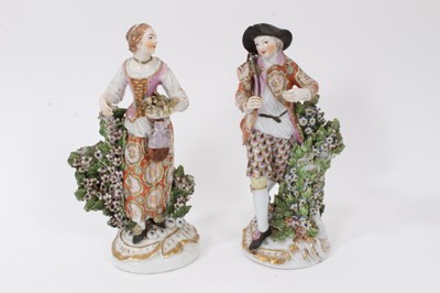 Lot 194 - Pair of Derby figures of harvesters, circa 1770, the man shown standing next to a flower-covered tree stump, holding a keg over one shoulder, on  a gilt scrollwork base, the woman similarly modelle...