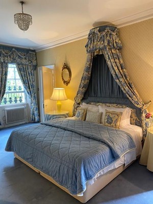 Lot 1341 - Traditional upholstered blue floral bedroom suite, comprising two single beds to make a super king bed, with canopy and matching curtains and pelmets, nursing chair