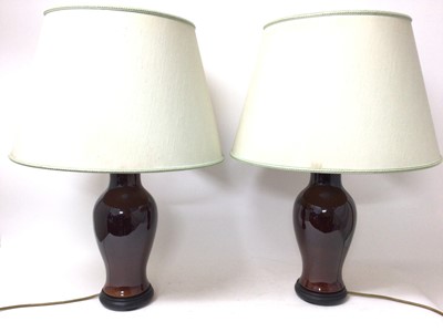 Lot 851 - Pair of Chinese style sang de boeuf vase lamps, with circular flared shades, 69cm high