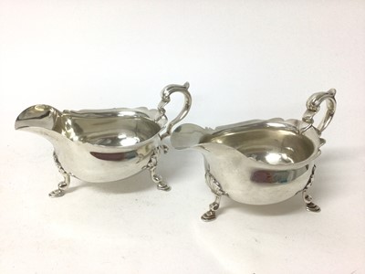 Lot 392 - Pair of sterling silver sauceboats, by Tessiers, London 1937, with scalloped rims, scroll handles, on stepped hoof feet, 12.9 troy oz.