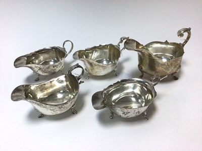 Lot 316 - Group of five silver sauce boats of conventional form with scroll handles (Various dates and makers)