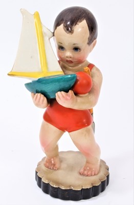 Lot 1194 - Lenci figure of a young boy in a swimming costume, holding a toy boat, spade and ball, marked 'Lenci Made in Italy' to base