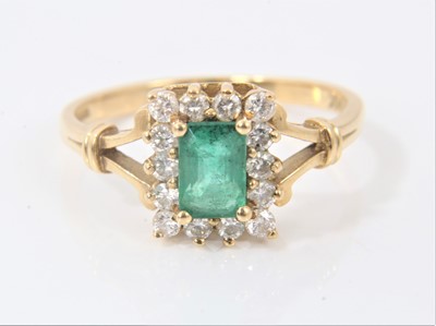 Lot 620 - Emerald and diamond cluster ring with a rectangular step cut emerald surrounded by a border fourteen brilliant cut diamonds in claw setting on 18ct yellow gold shank. Ring size R.