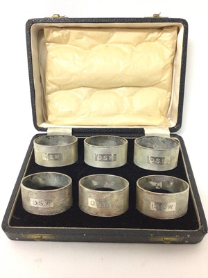 Lot 439 - Set of six silver napkin rings with engine turned decoration and engraved initials, and family crest, in fitted box. Elkington &Co. Birmingham 1948. Approximately 11 troy oz.