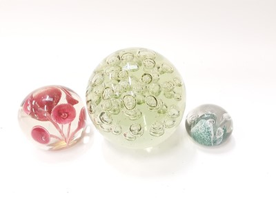 Lot 1310 - Very large art glass paperweight with bubble decoration, together with two other colourful glass paperweights (3)