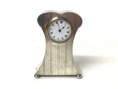 Lot 423 - George V silver mounted dressing table clock in shaped case with reeded engine turned decoration, raised on bun feet, (Birmingham 1913), maker David Moss & Co, 9cm in height