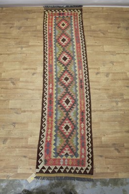 Lot 1512 - Kelim style runner, with repeat lozenge medallion in muted tones, 289 x 74cm