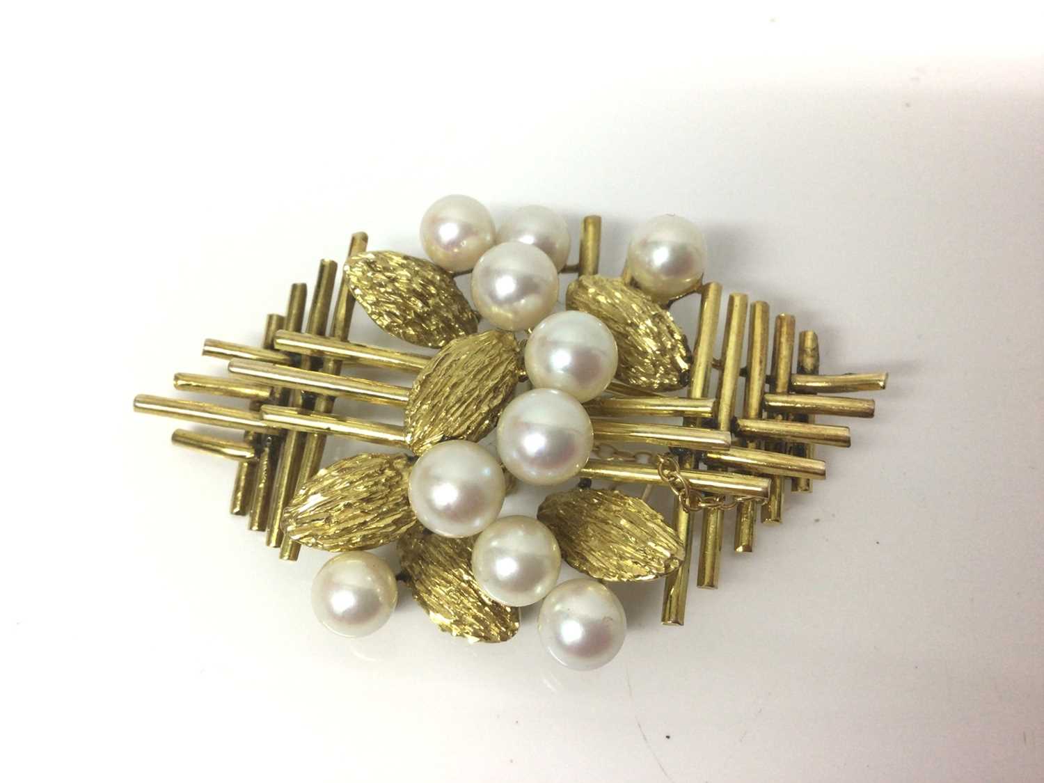 Lot 84 - 1960s 14ct gold and cultured pearl floral spray brooch with ten 6-6.8mm cultured pearls in a 14ct yellow gold grid design amongst gold leaves. 60mm.