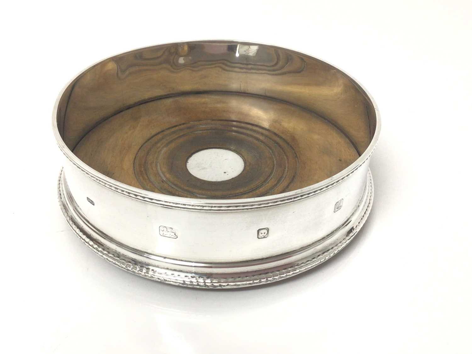 Lot 62 - Contemporary silver wine coaster with beaded border and turned wooden base, 13cm diameter