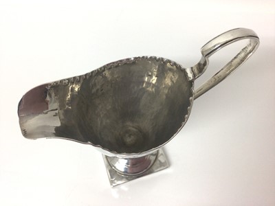 Lot 60 - Georgian silver cream jug of helmet shaped form, on square foot