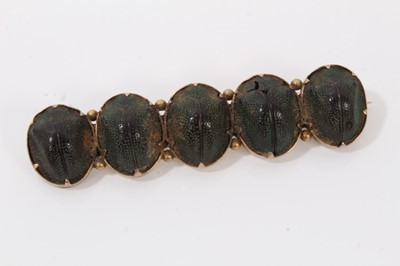 Lot 198 - Egyptian Revival brooch mounted with five scarab beetles, together with another mounted with a single scarab beetle and a locket made from a hazelnut (3)