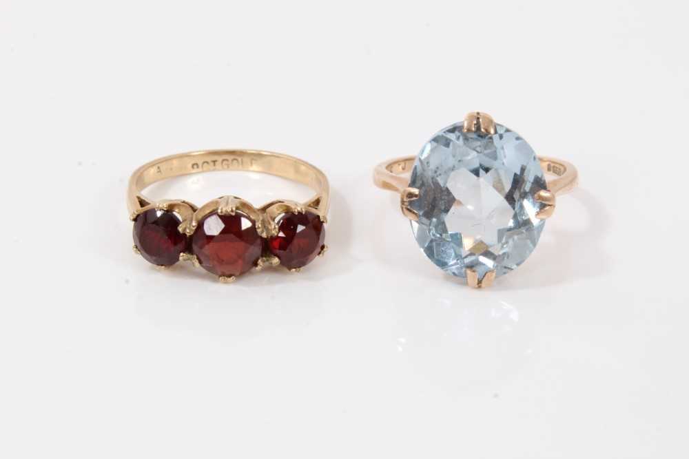 Lot 209 - 9ct gold oval faceted blue stone cocktail ring and 9ct gold garnet three stone ring (2)