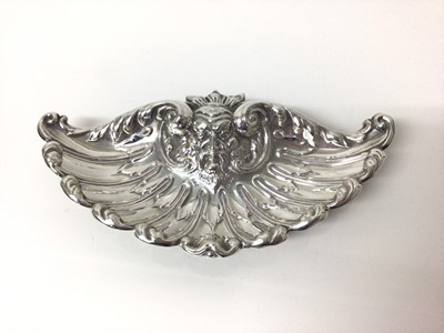 Lot 119 - Good quality sterling silver dish, of shell form, repousse decorated with scrollwork motifs and a grotesque mask, on three bun feet, hallmarked Sheffield 1895, 19cm across